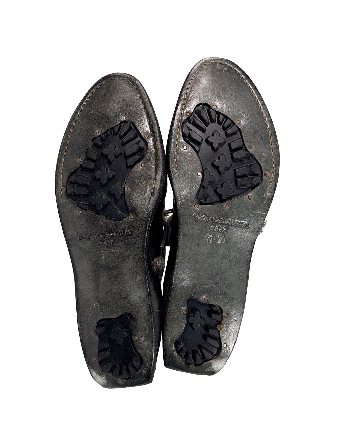Pair of worn leather shoes with visible brand name on a white background