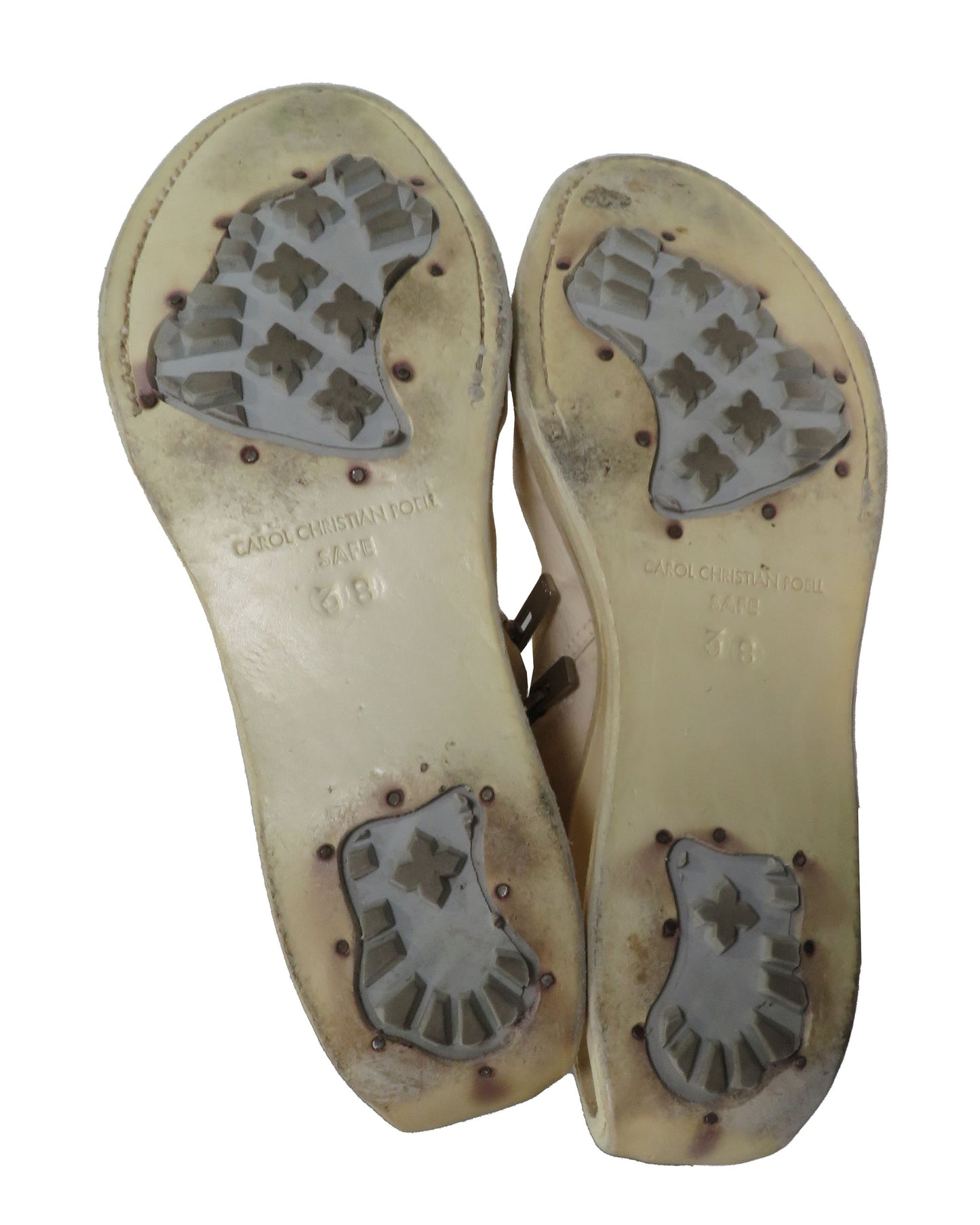 Dirty shoe soles with visible wear and scuff marks on a white background