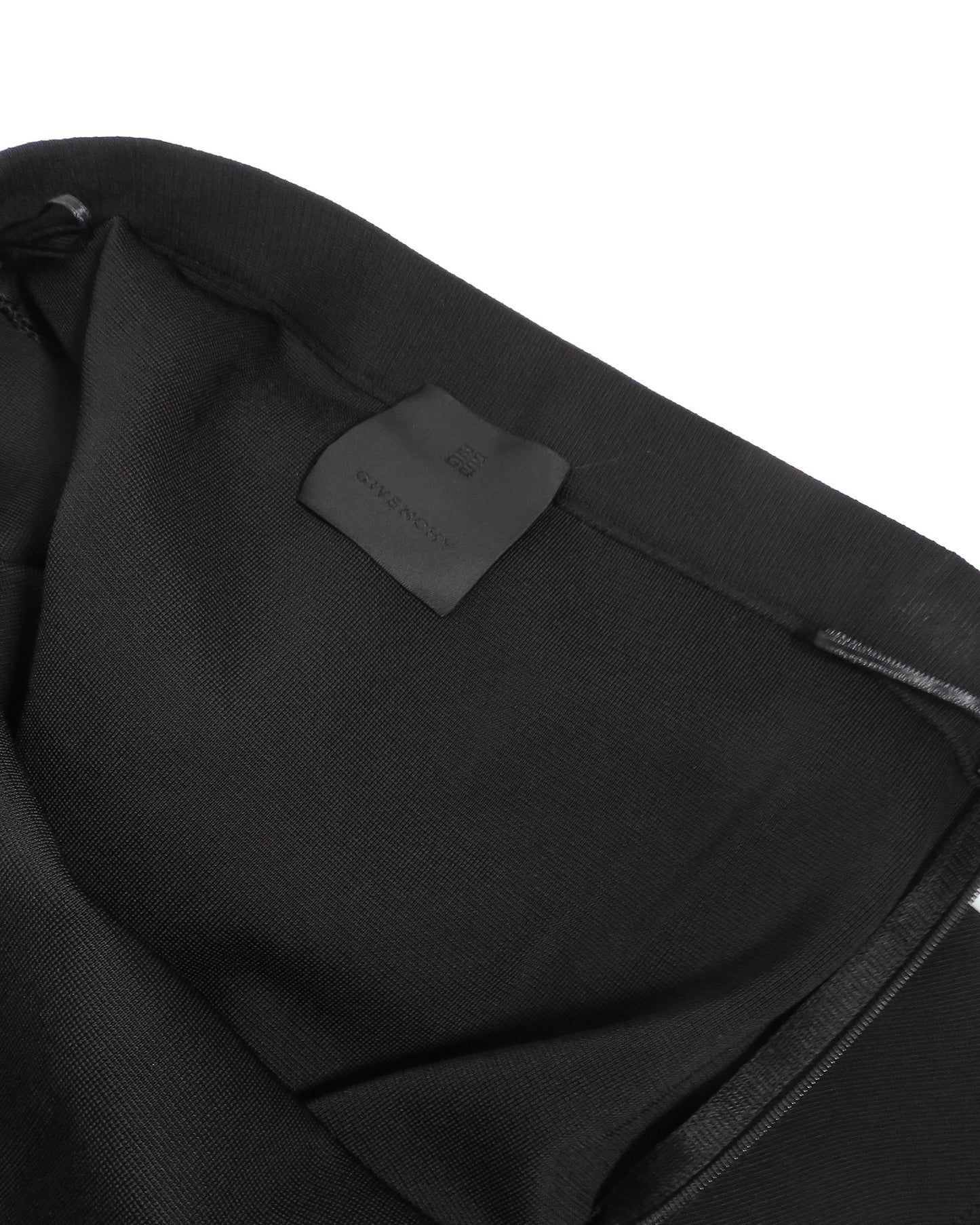 Close-up of a black garment with a brand label on a white background