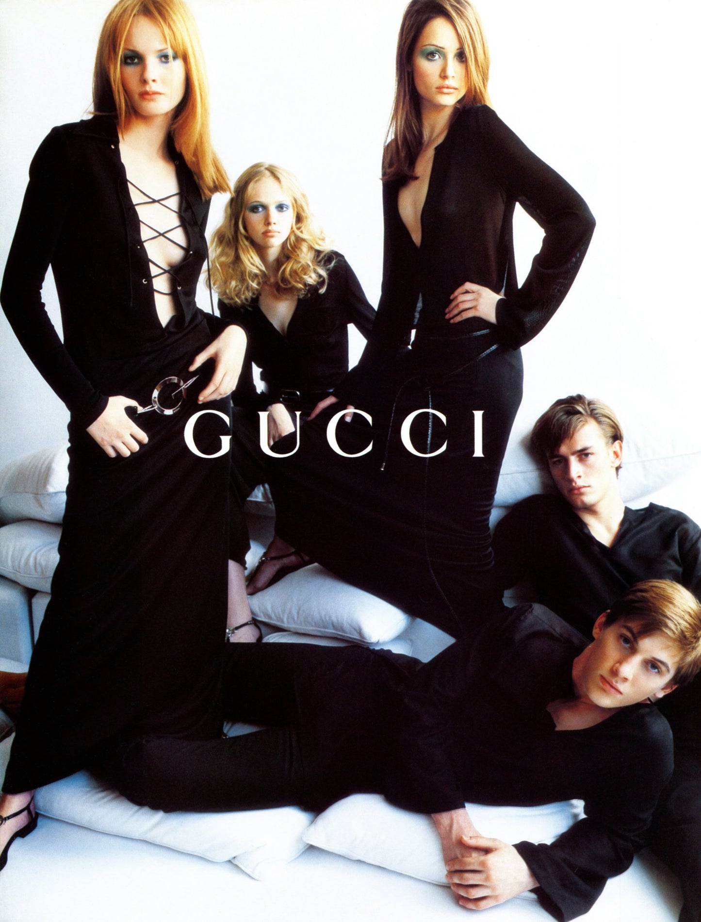 Gucci advertisement featuring models in black outfits on a white background