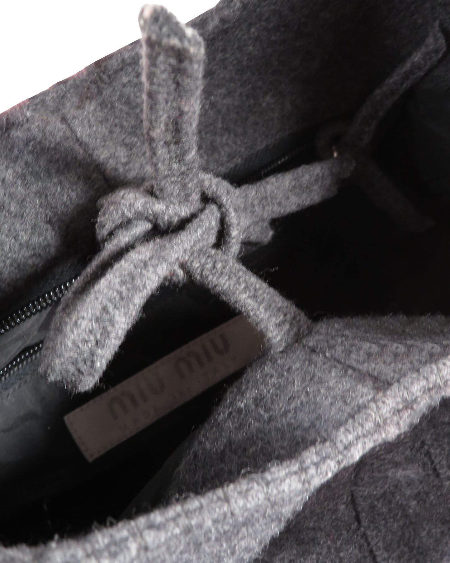 Close-up of a gray textured fabric with a brand label partially visible.