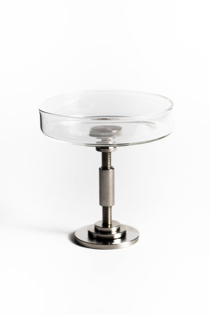 Clear glass dish with metal stand on a white background