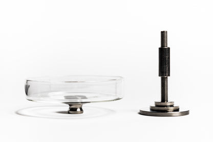 Clear glass cake stand with metal base on a white background