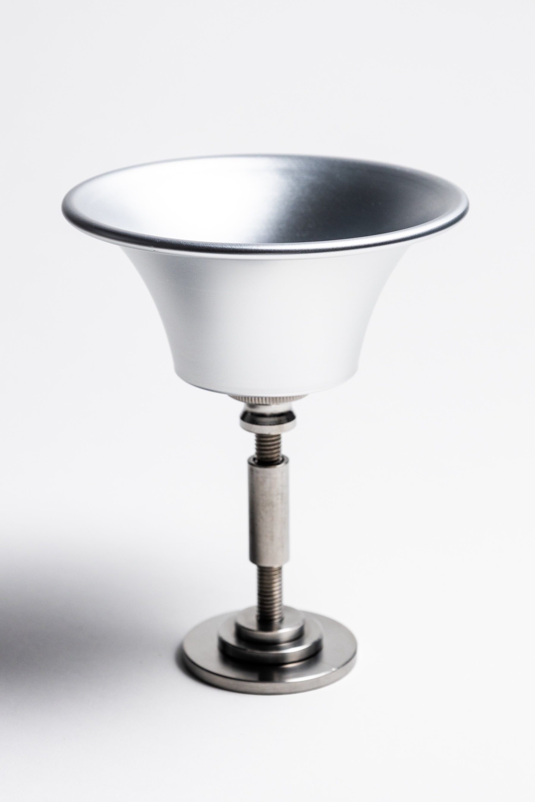 Metallic glass holder with a white bowl on a white background