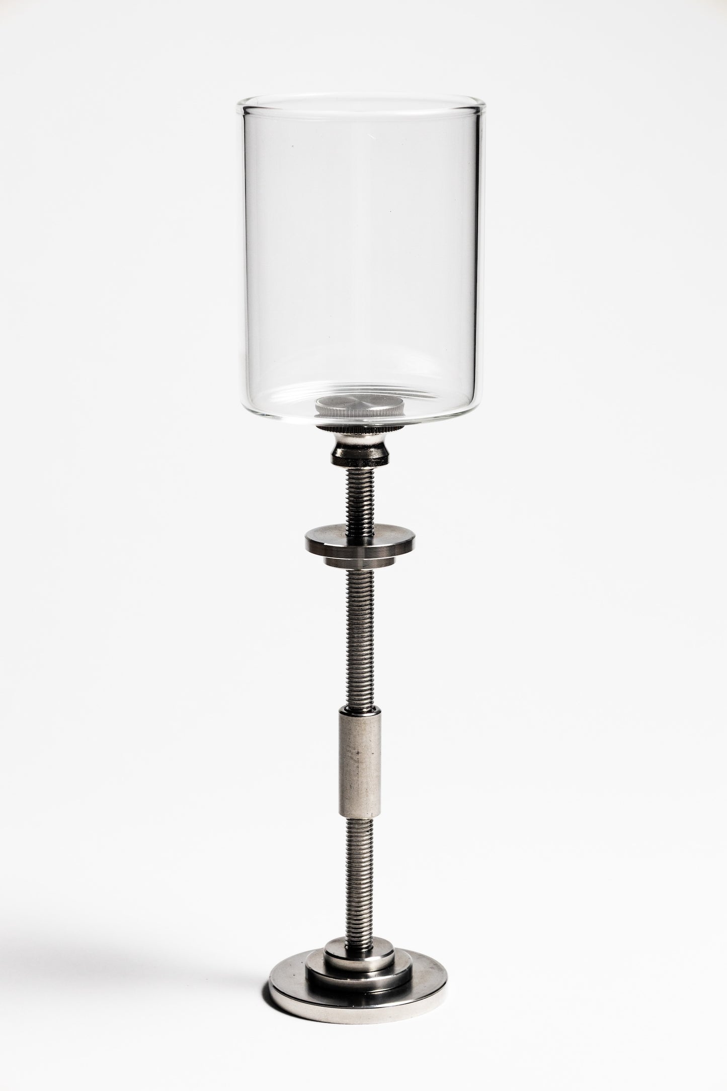 Clear glass candle holder on a metal stand with adjustable height on a white background