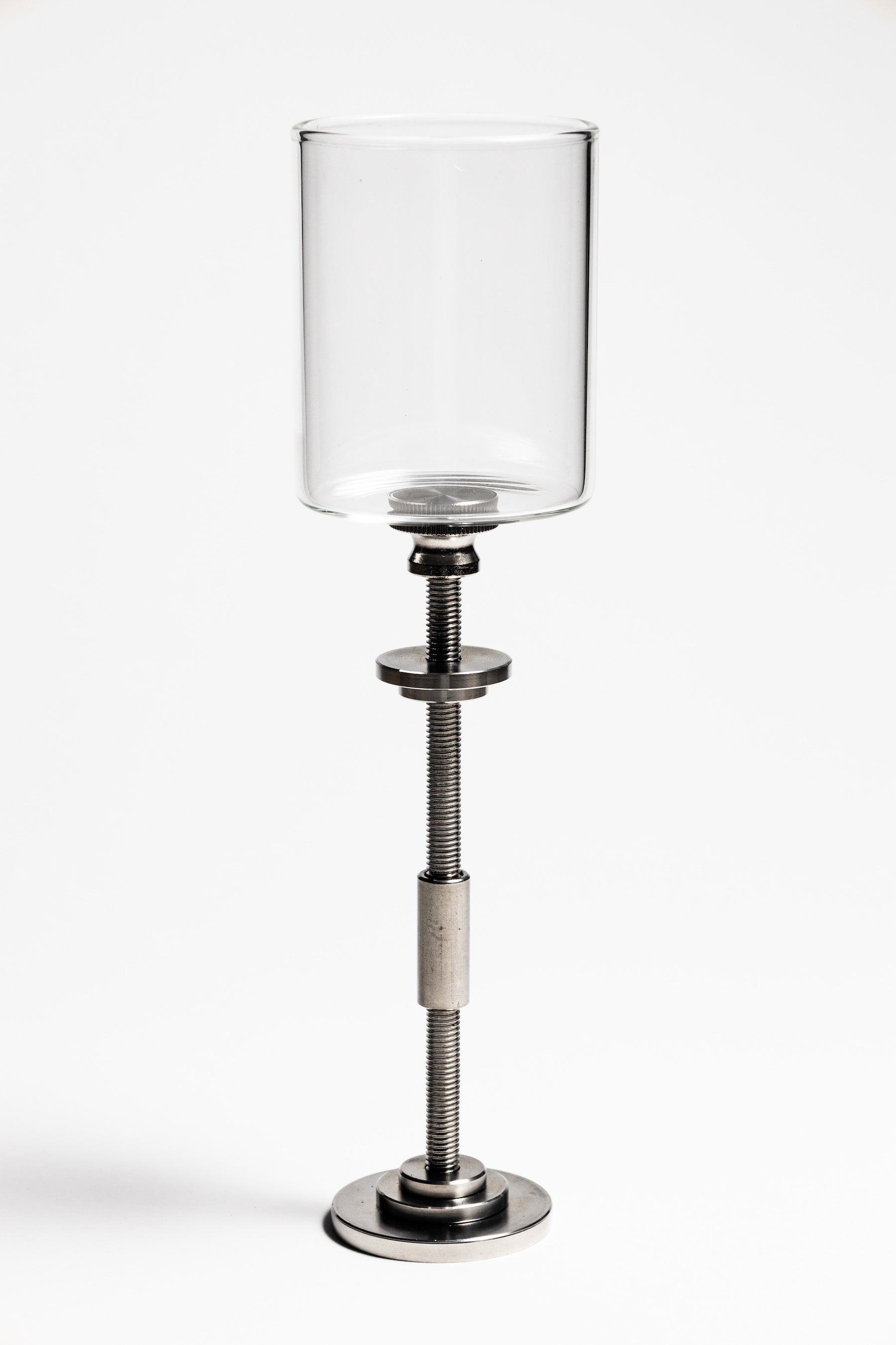 Clear glass candle holder on a metal stand with adjustable height on a white background