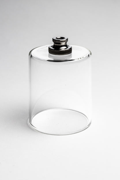 Clear glass container with a metallic cap on a white background