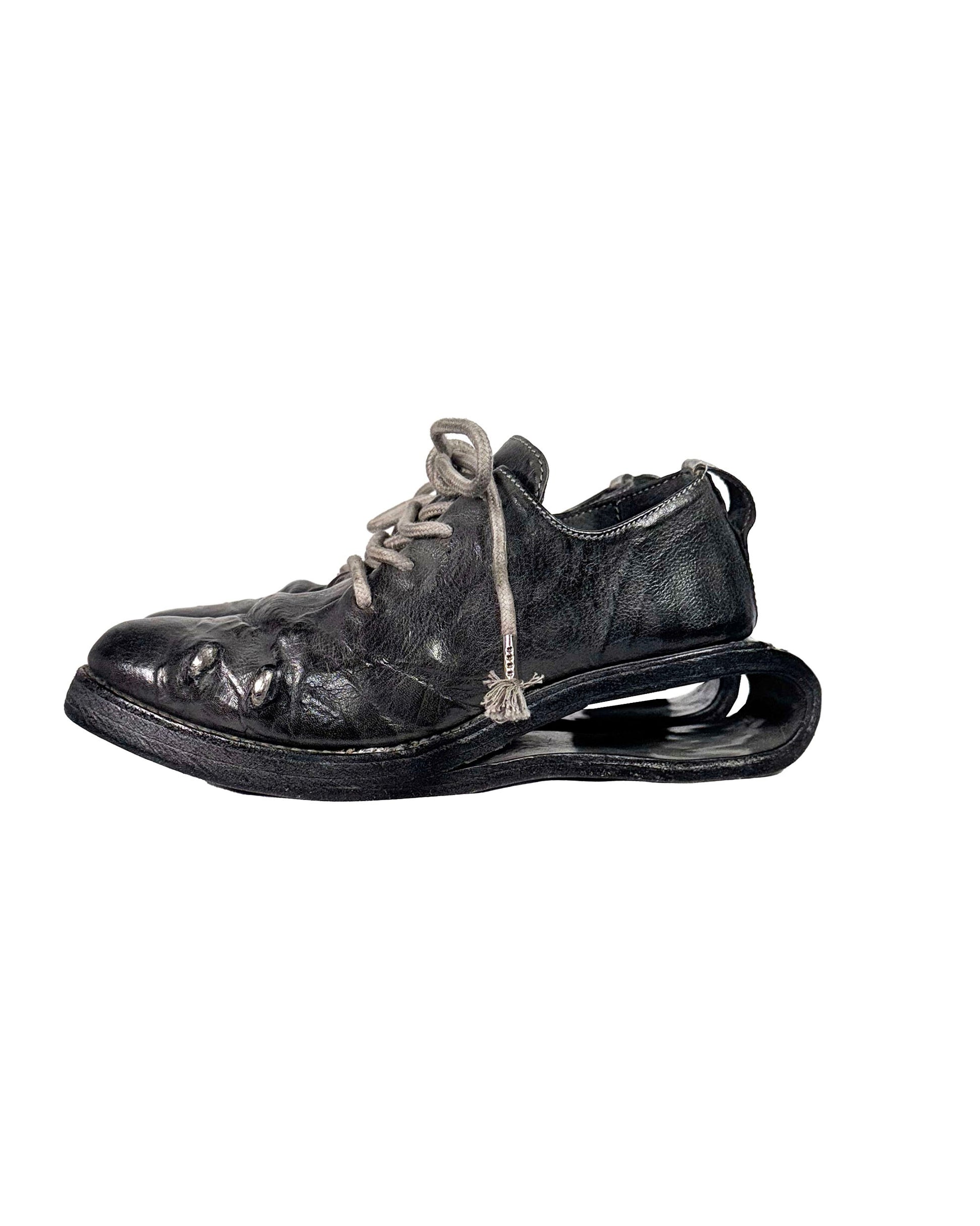 Old leather shoe with a thick sole on a white background