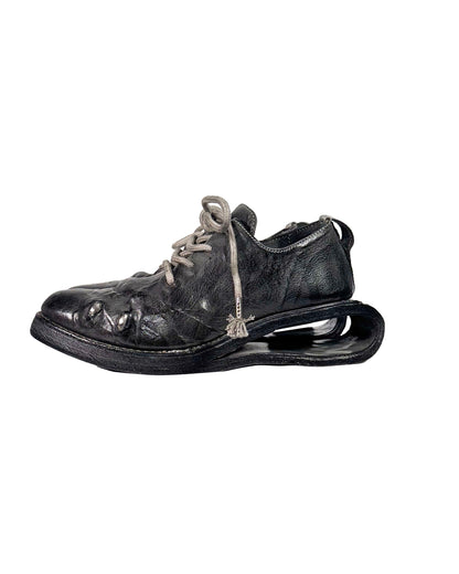 Old leather shoe with a thick sole on a white background