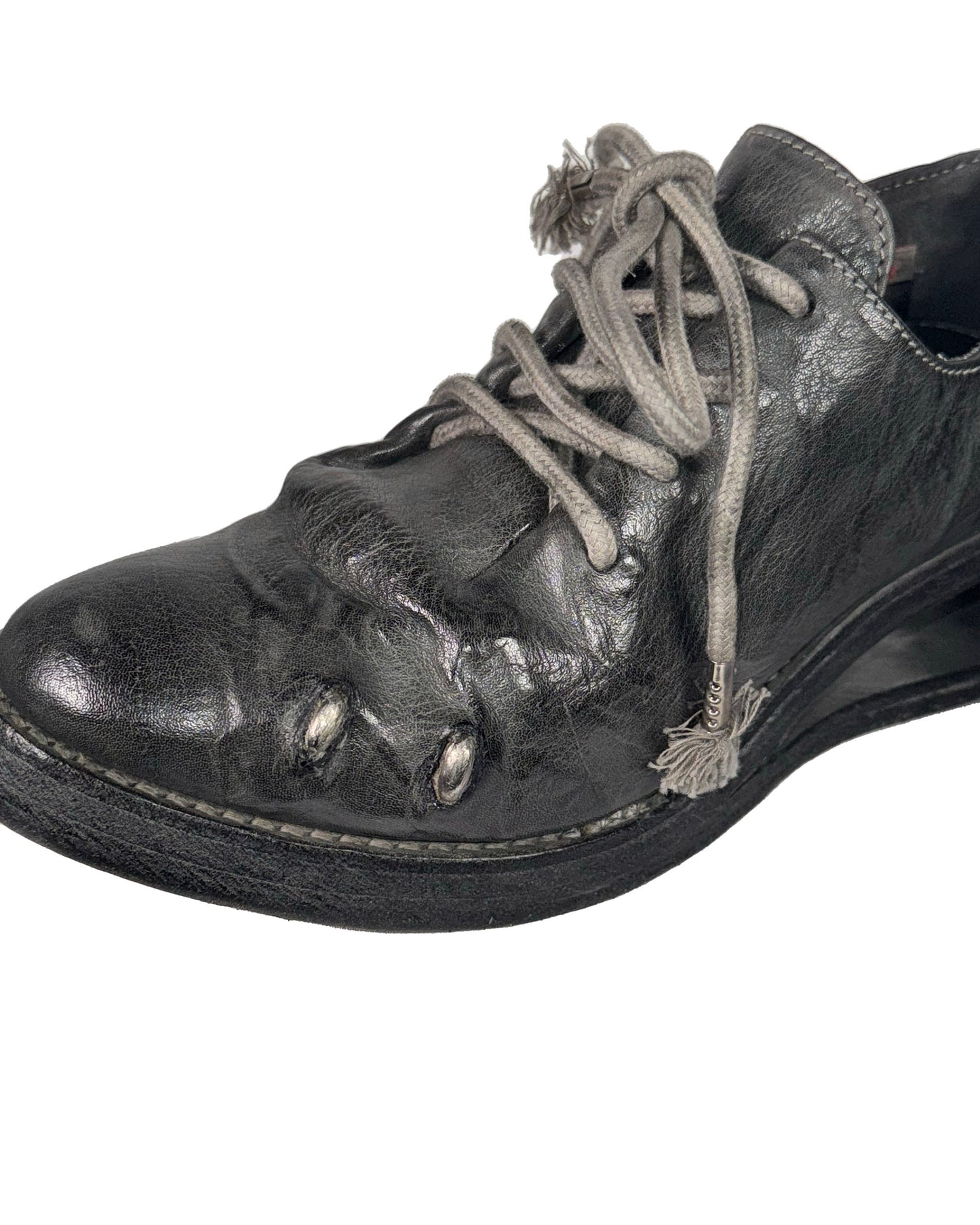 Black leather shoe with beige laces on a white background