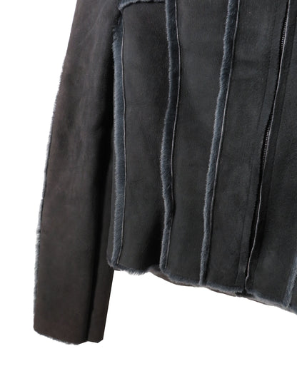 Close-up of a dark gray suede jacket with frayed edges on a white background