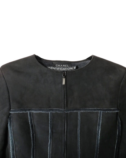 Close-up of a black leather jacket with Chanel branding on a white background