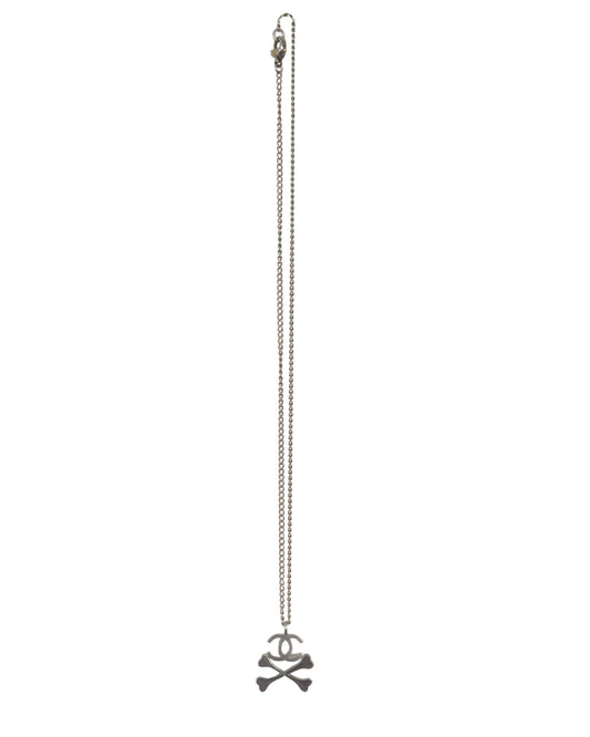 Silver necklace with a pendant on a white background. Chanel FW2003 Skull and Crossbones CC Logo Necklace. - vothe archive - curated designer vintage 