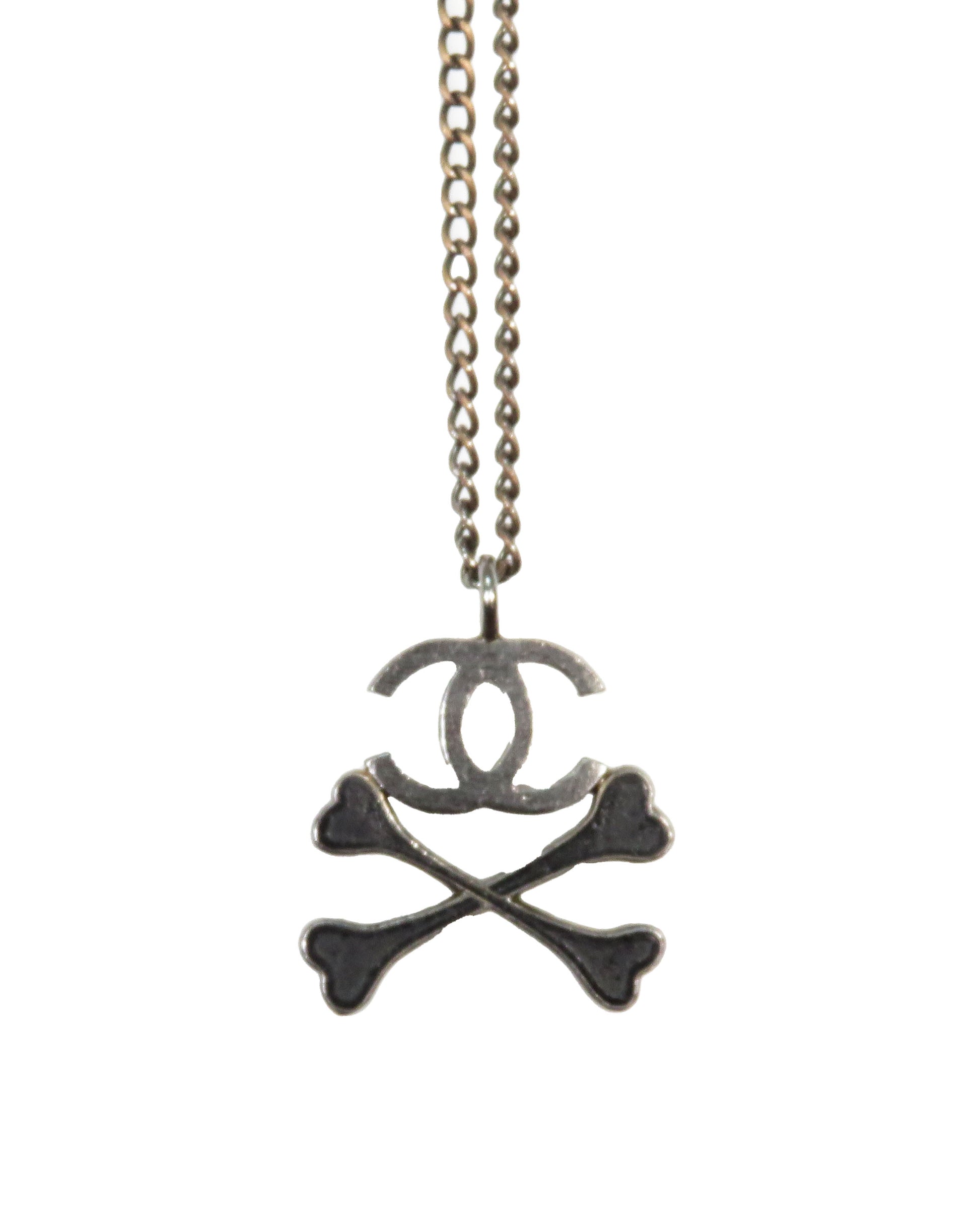 Chanel necklace with skull and crossbones design on a white background
