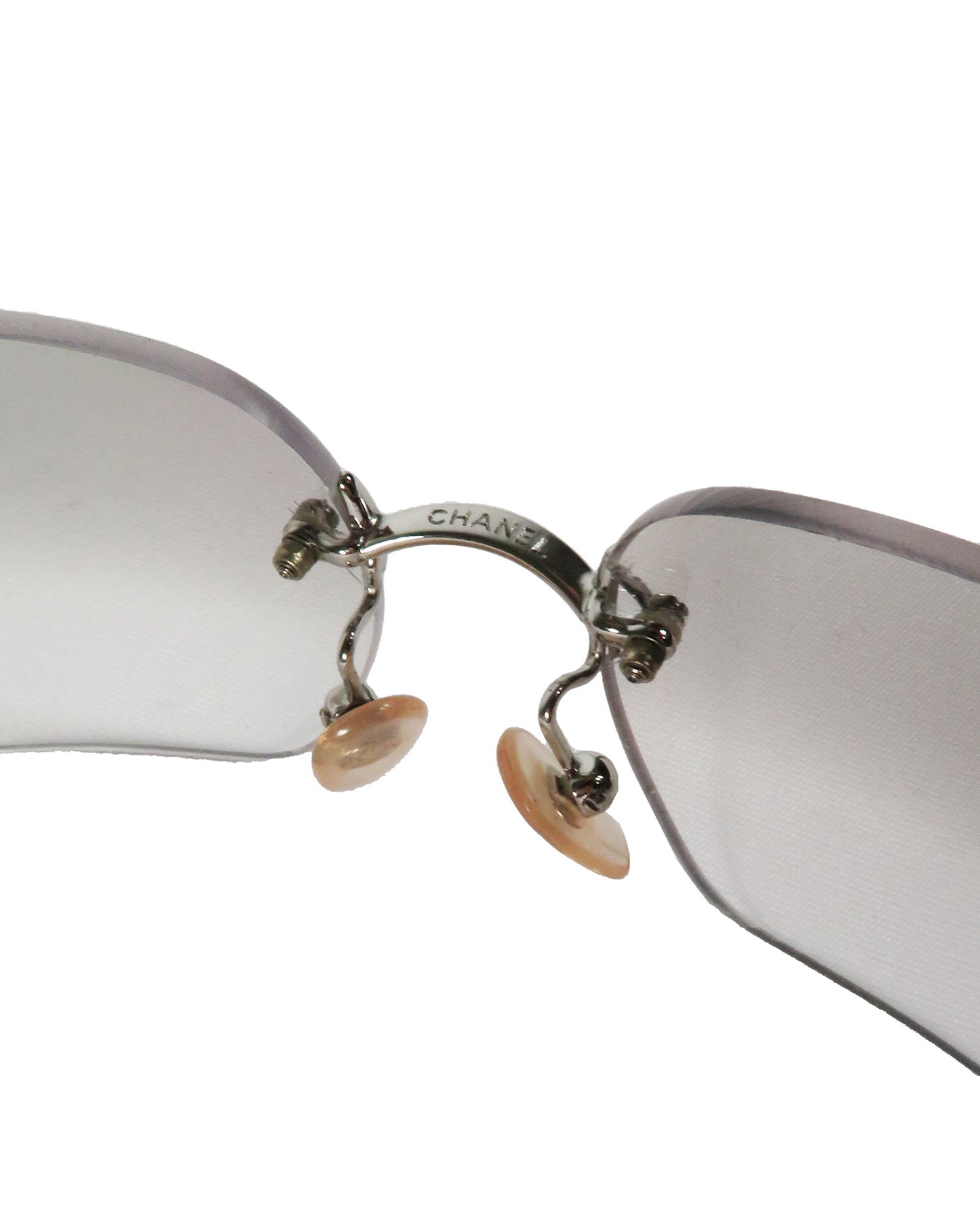 Close-up of a pair of Chanel sunglasses with reflective lenses on a white background