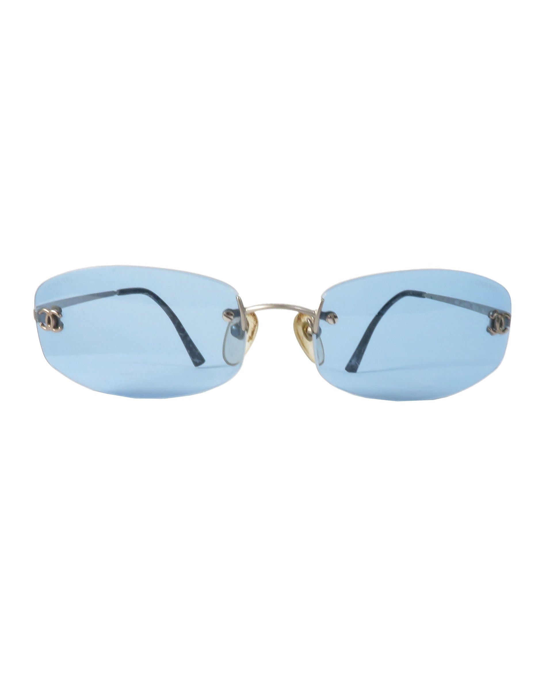 Sunglasses with blue lenses and gold frames on a white background