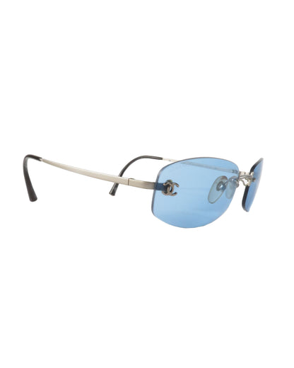 Sunglasses with blue lenses and thin metal frame on a white background