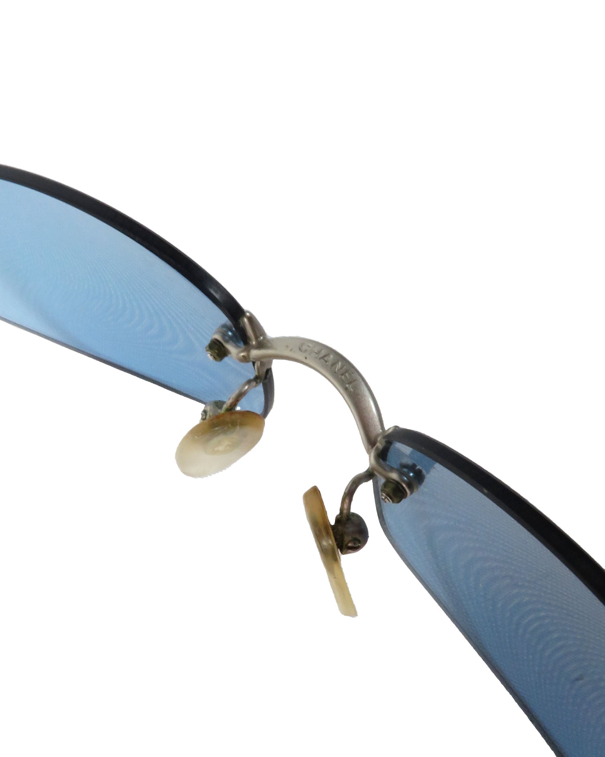 Close-up of a pair of sunglasses with blue lenses and black frames on a white background.