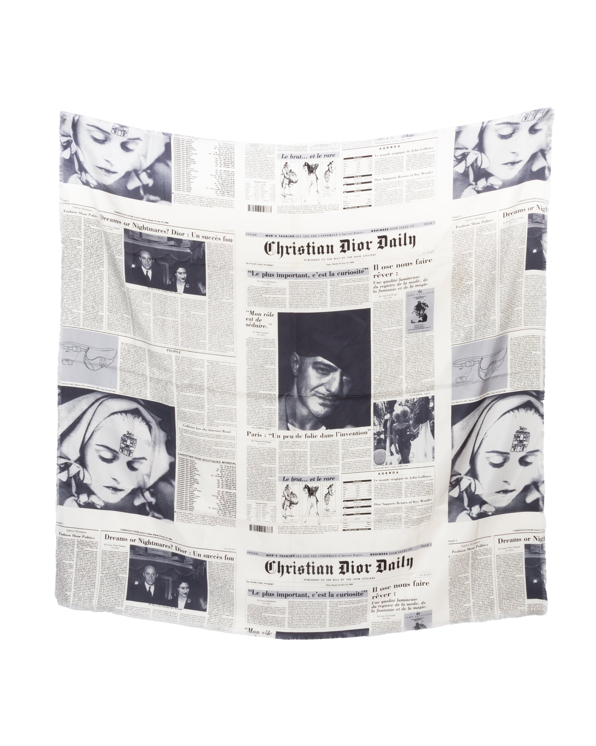 A Christian Dior silk scarf with a monochrome newspaper print design, featuring vintage-style headlines and photographs, displayed flat with fringe edges visible.