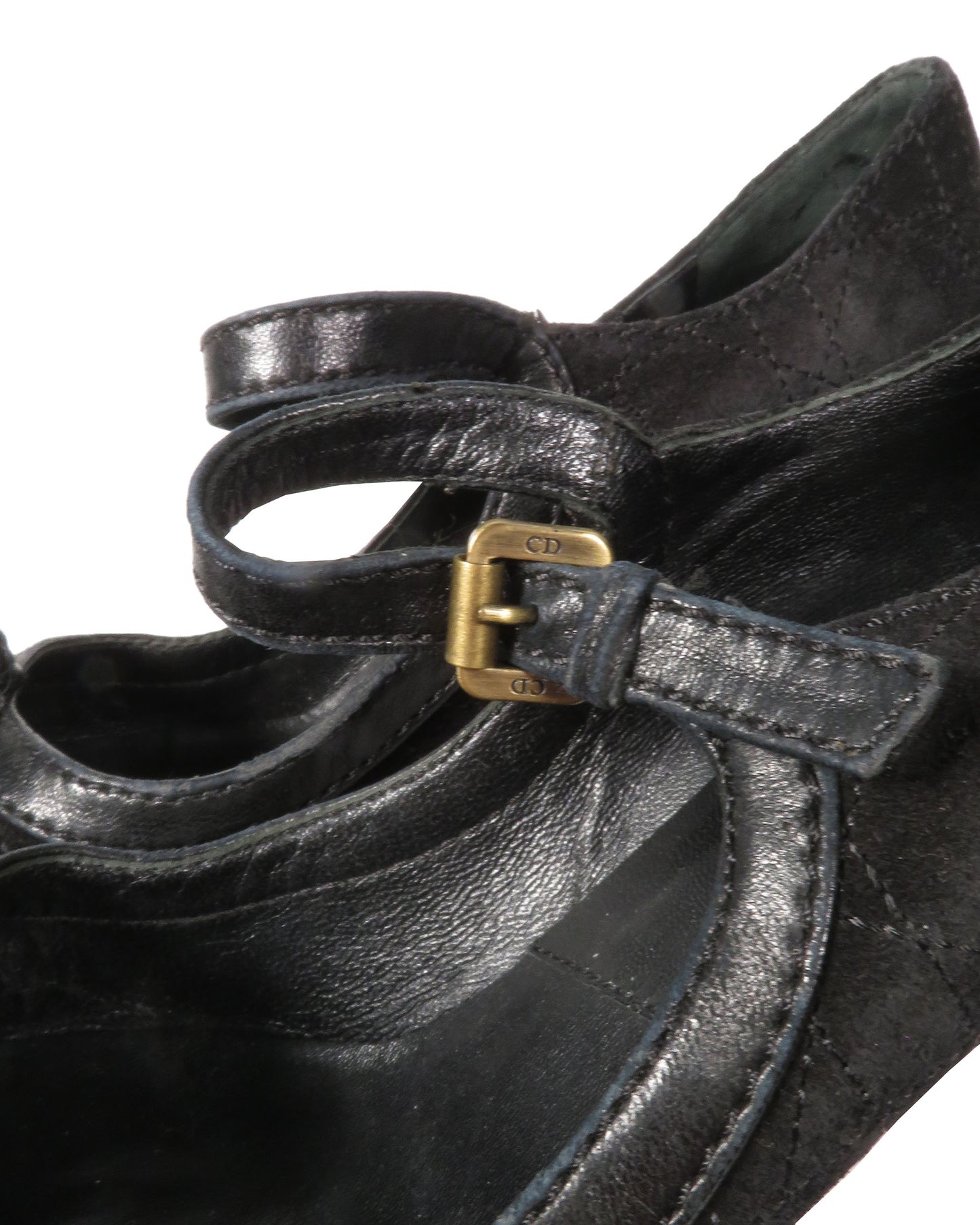 Black leather shoe with a gold buckle on a white background