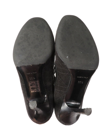 Black high-heeled shoes with soles facing up on a white background