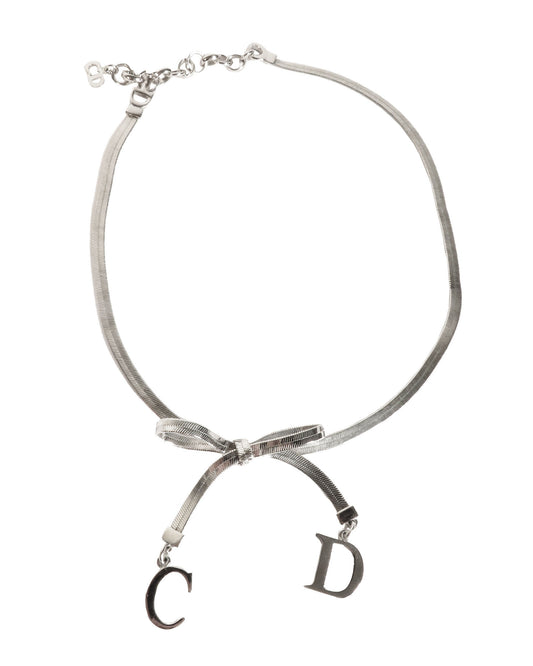 Necklace with a bow and 'CD' charms on a white background