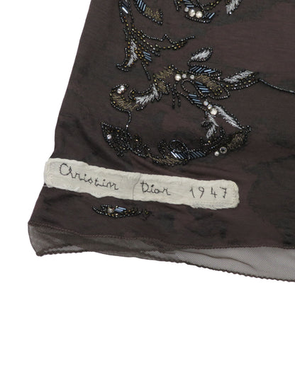 Embroidered fabric with 'Christian Dior 1947' label on a white background