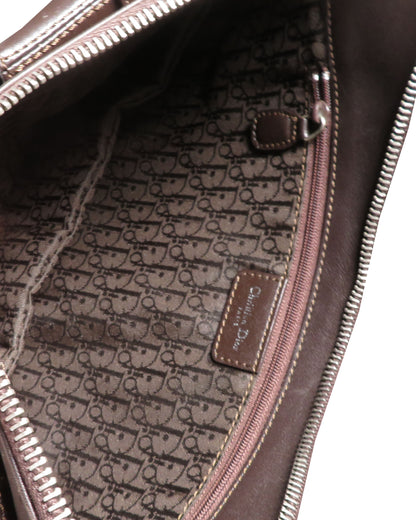 Close-up of a brown leather bag with a patterned interior and visible brand logo.