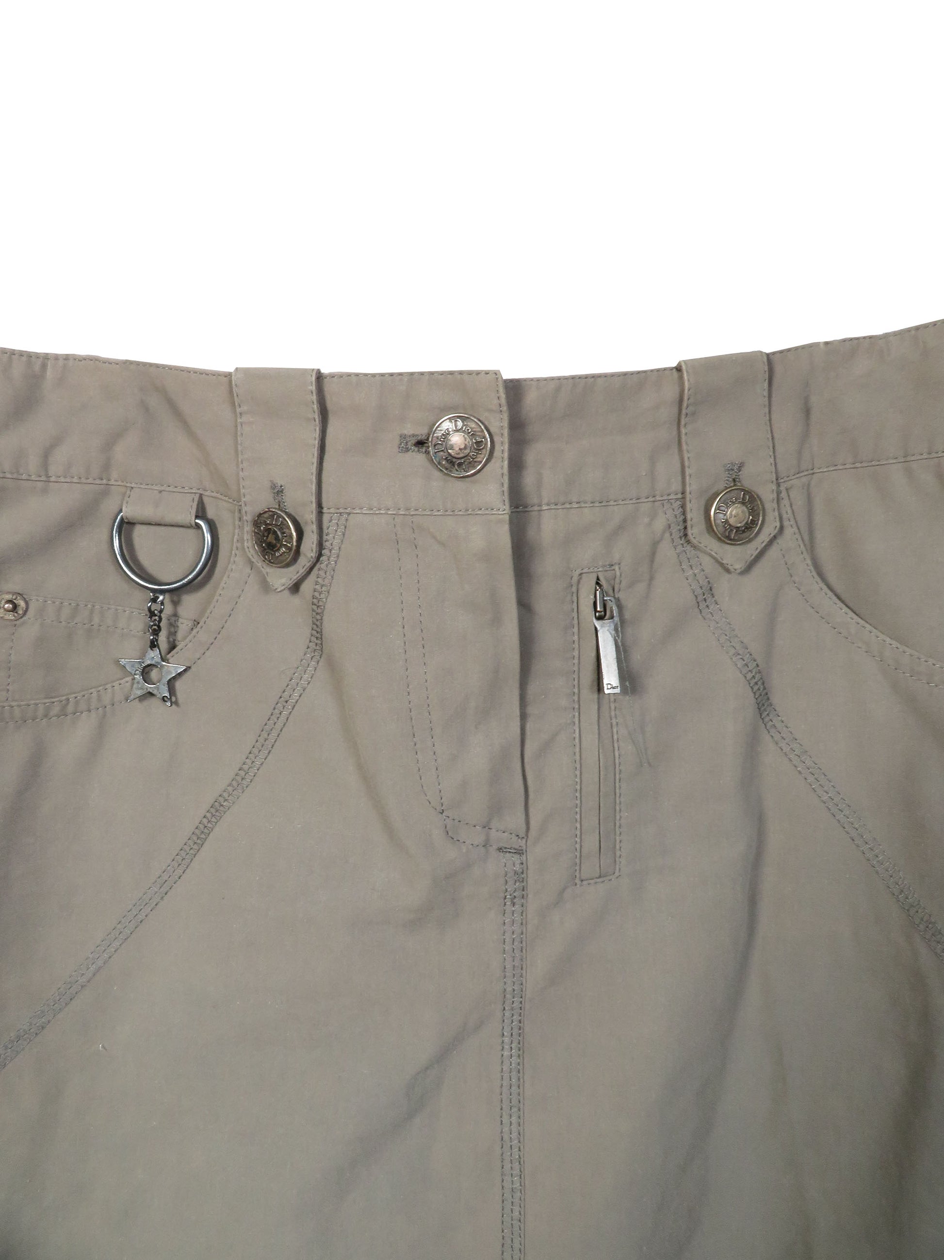 Close-up of beige pants with zippers and buttons on a white background