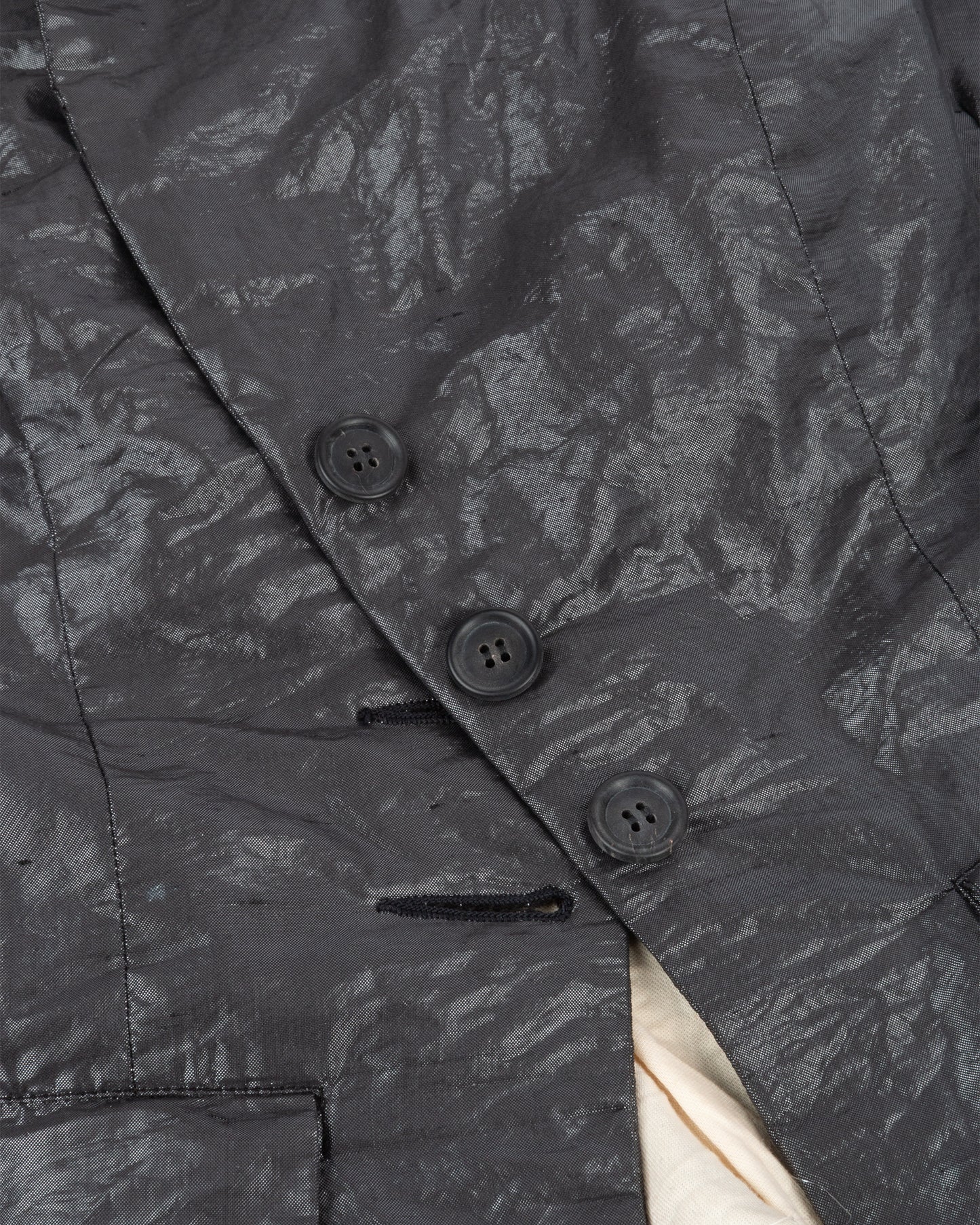 Close-up of a dark textured jacket with buttons