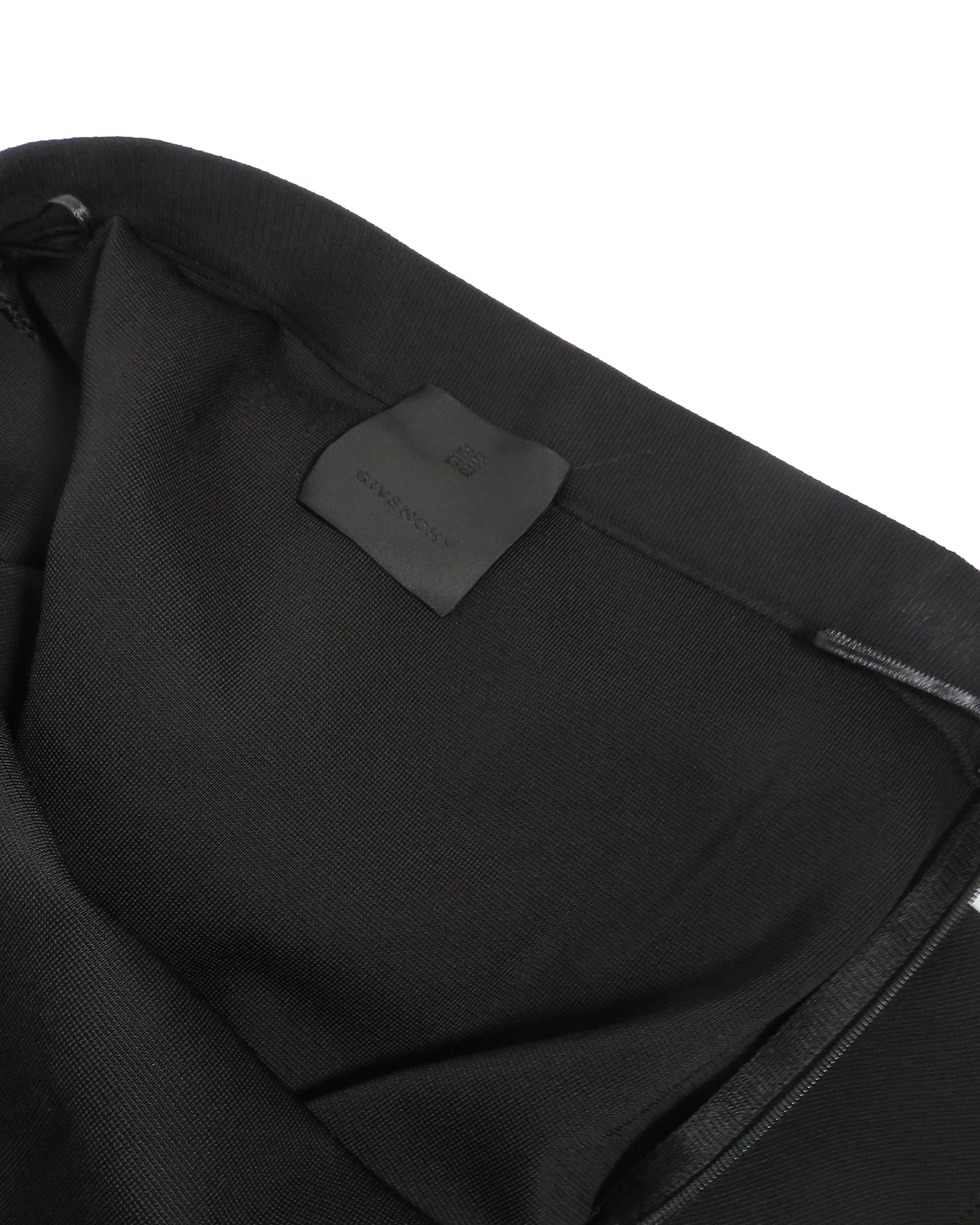 Close-up of a black garment with a brand label on a white background