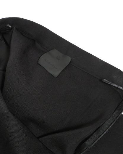 Close-up of a black garment with a brand label on a white background