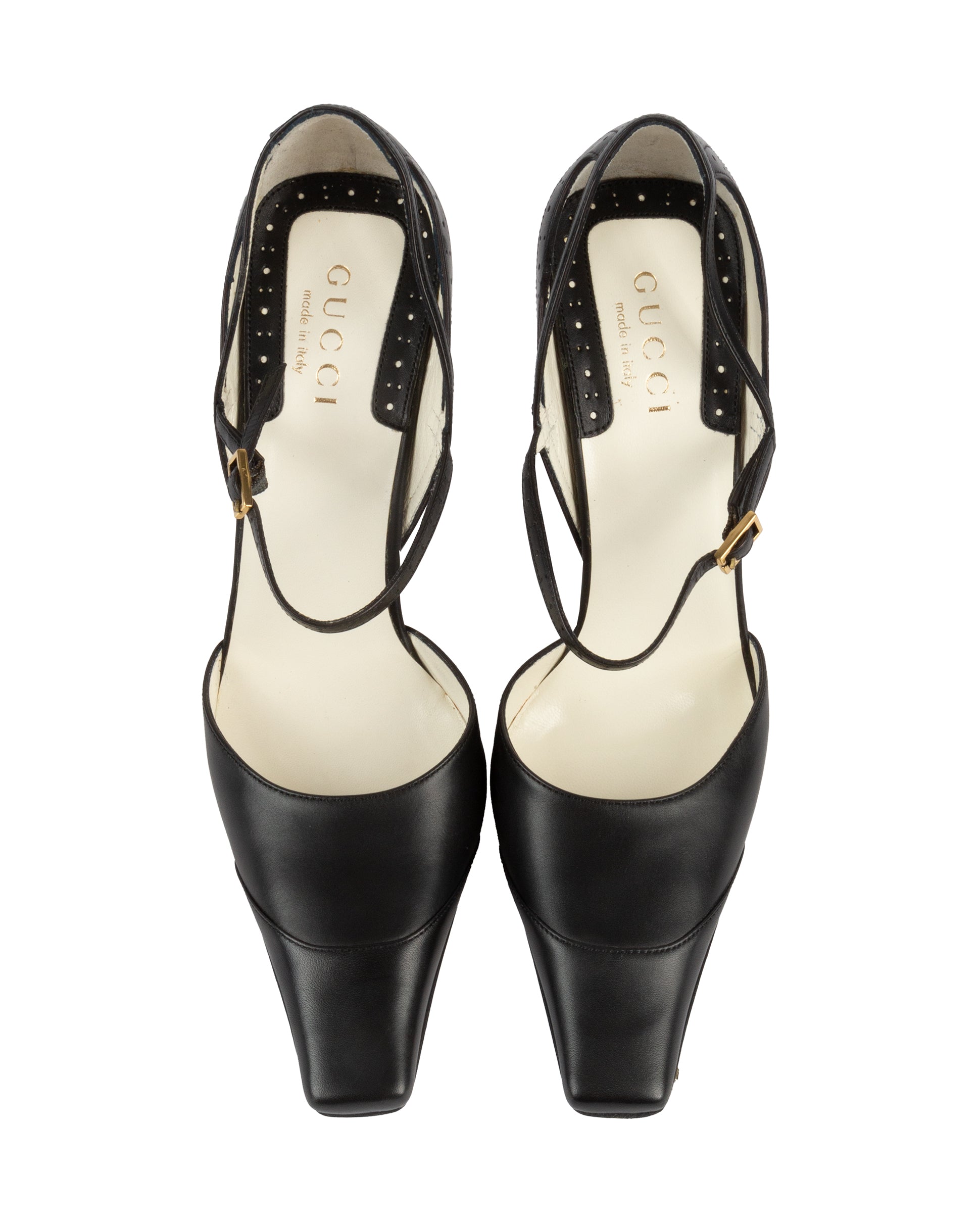 Pair of black high-heeled shoes with Gucci logo on a white background
