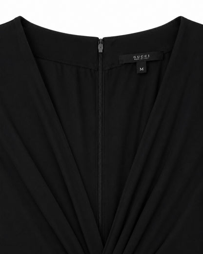 Black garment with Gucci label on a white background