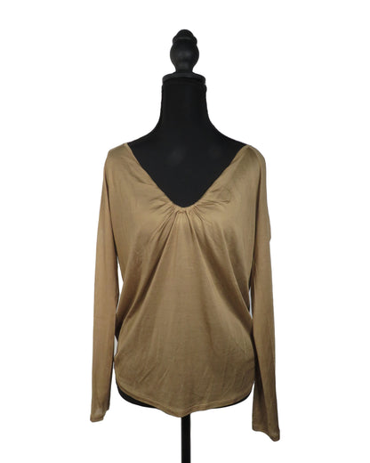 Beige long-sleeve top on a black mannequin against a white background