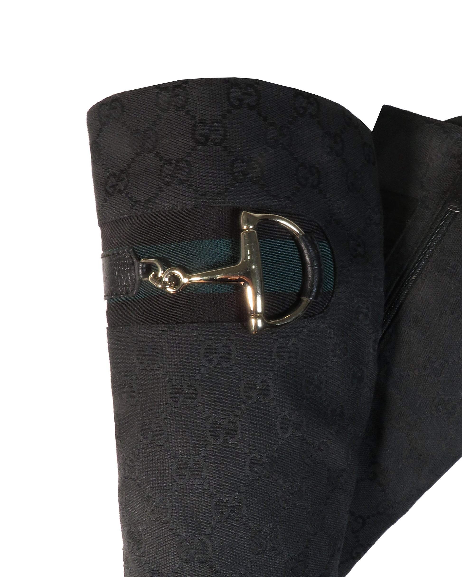 Black Gucci-patterned fabric with a gold horsebit buckle on a white background