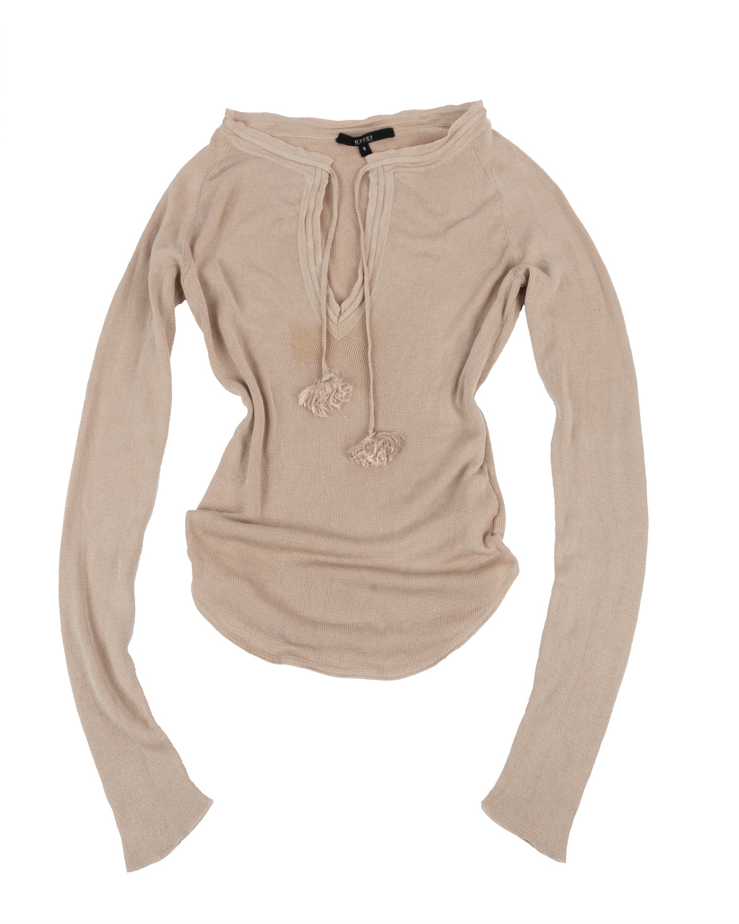 Beige silk long sleeve top with deep v-neckline and tassel tie closures, ribbed trim along the neckline, and subtle waist shaping. The top is displayed on a white background.