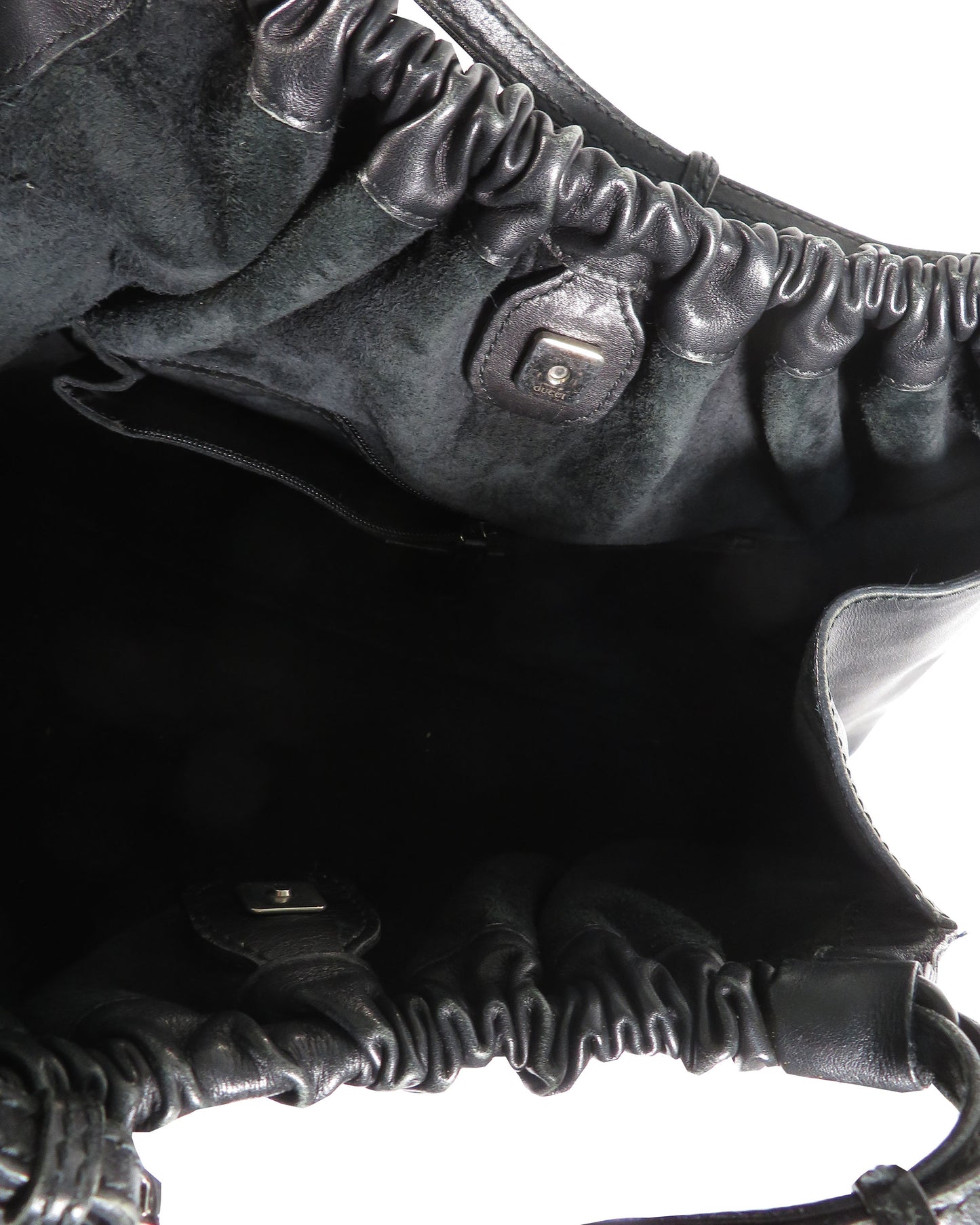 Close-up of a textured black leather bag with a zipper.