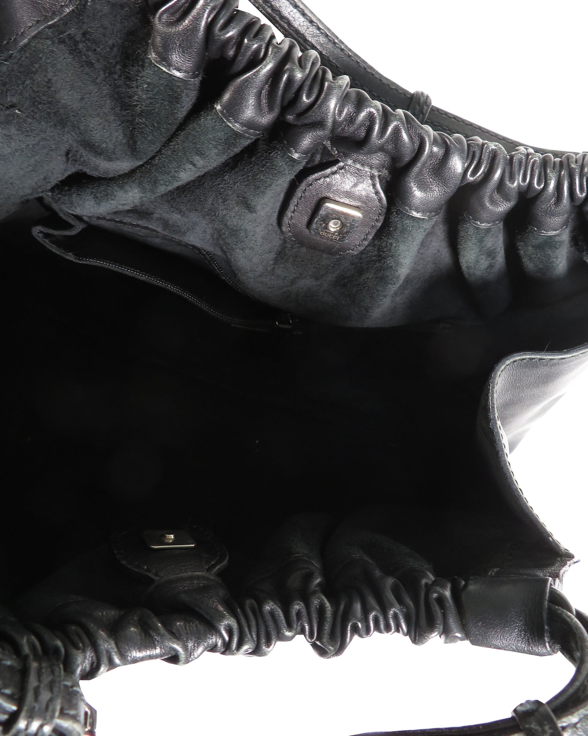 Close-up of a textured black leather bag with a zipper.