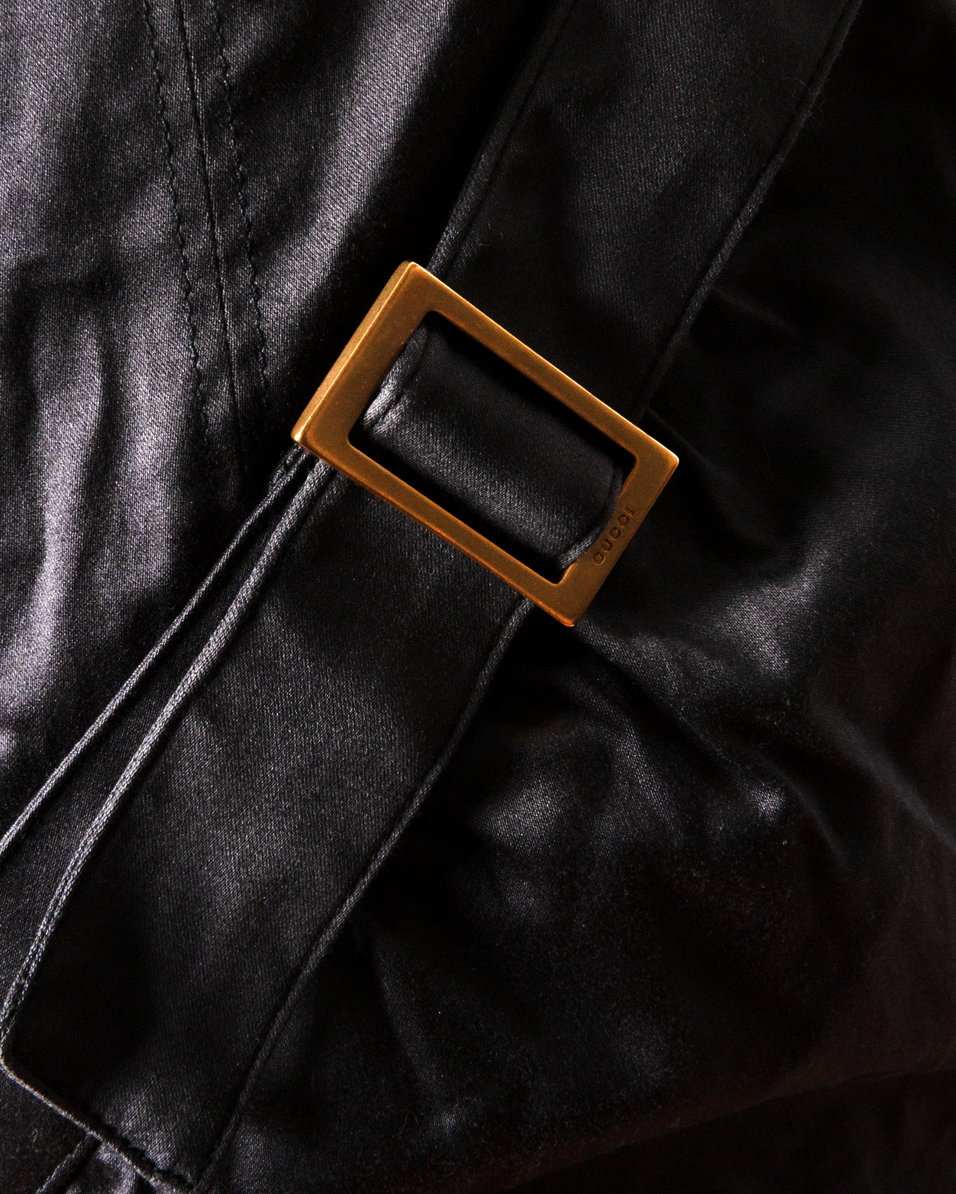 Close-up of a leather belt with a buckle on black leather.