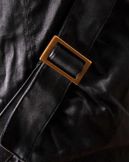 Close-up of a leather belt with a buckle on black leather.