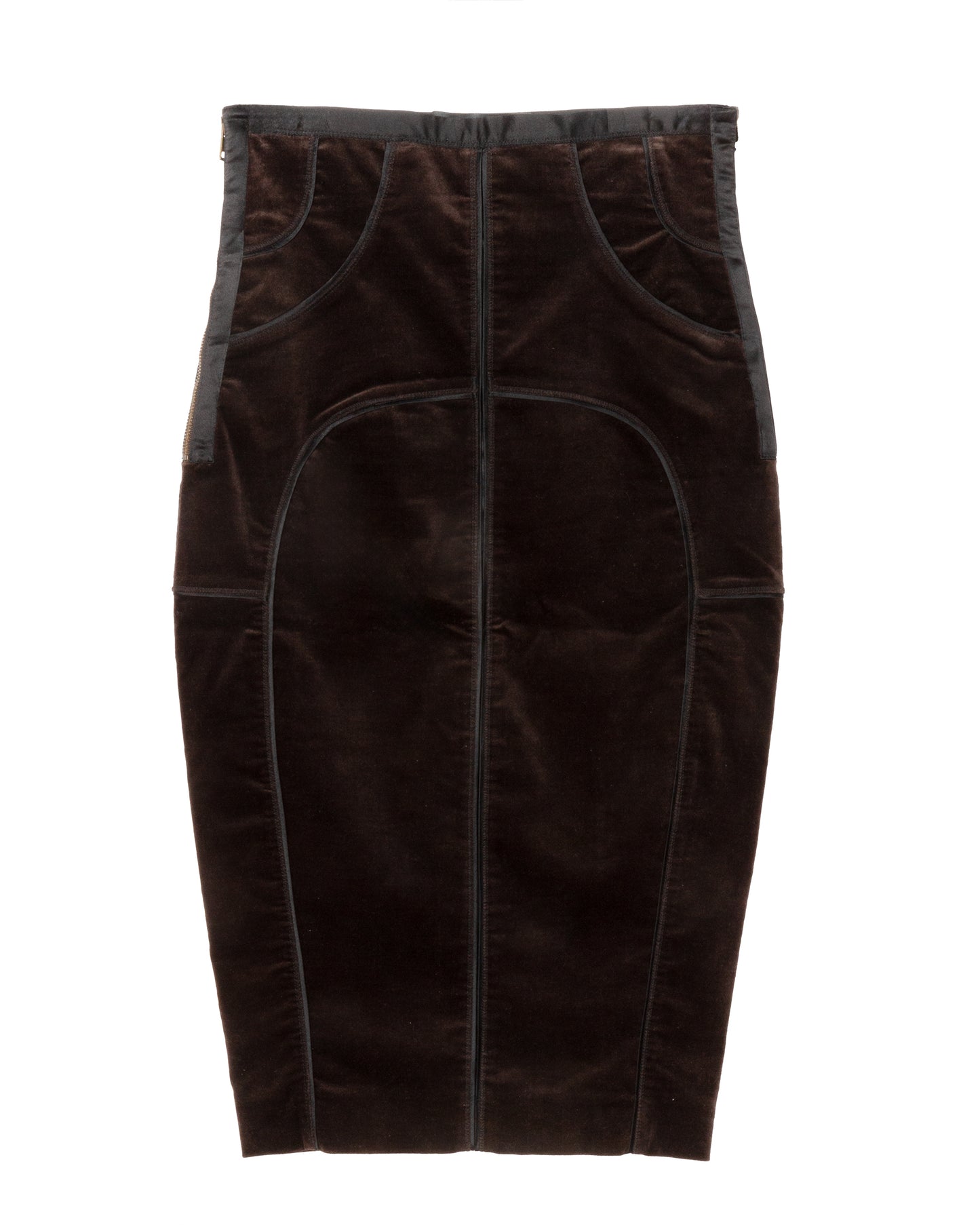 A dark brown velvet pencil skirt with curved seaming and structured panel construction. It features contrast satin trims along the waistband and side seams, a side zip closure, and a rear slit at the hem.