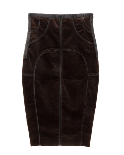 A dark brown velvet pencil skirt with curved seaming and structured panel construction. It features contrast satin trims along the waistband and side seams, a side zip closure, and a rear slit at the hem.