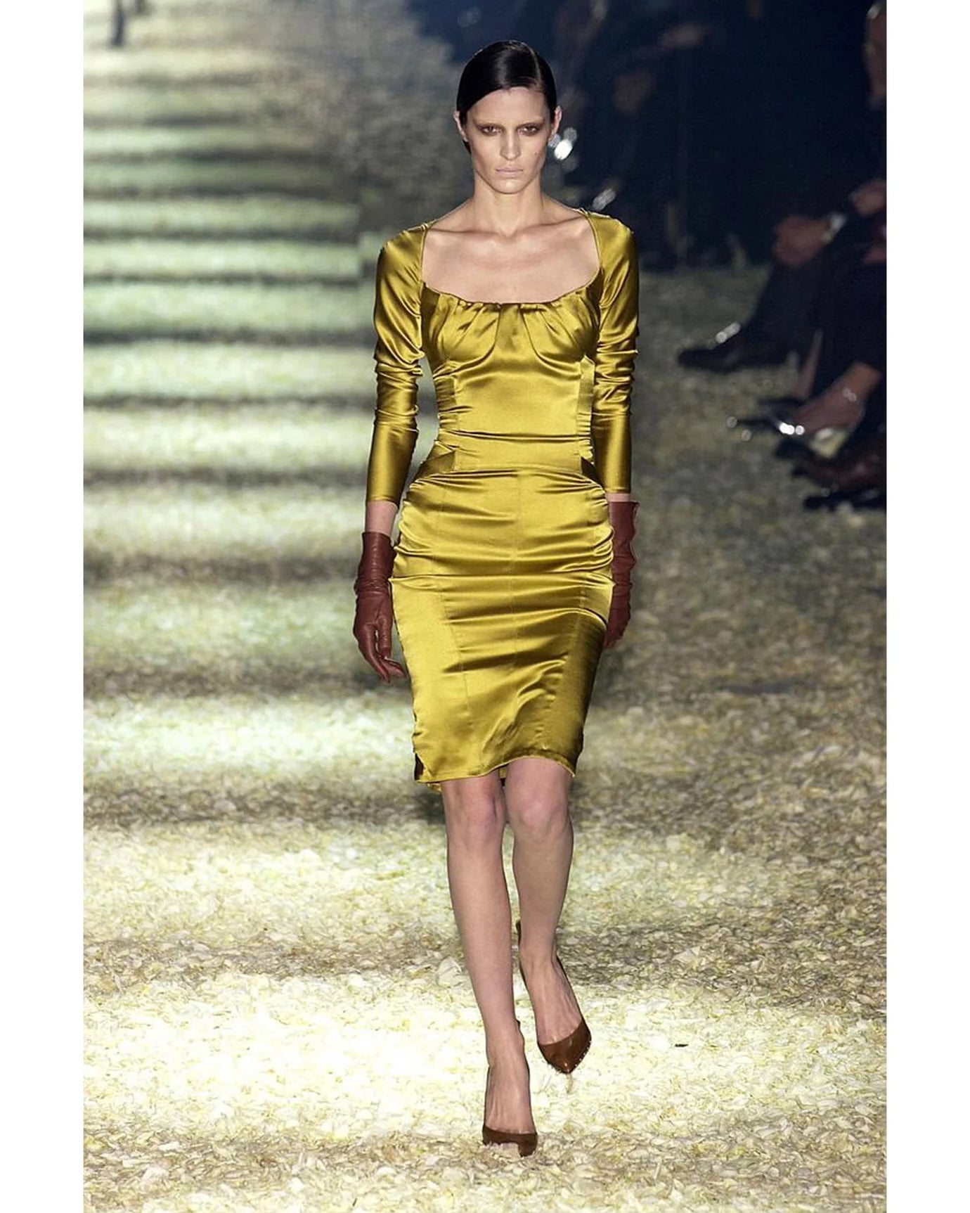 Model wearing a yellow dress on a runway