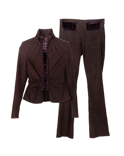 A two-piece outfit with a satin-finish jacket with a high collar and velvet trim, and matching straight-leg trousers with velvet pocket details, both in dark purple.