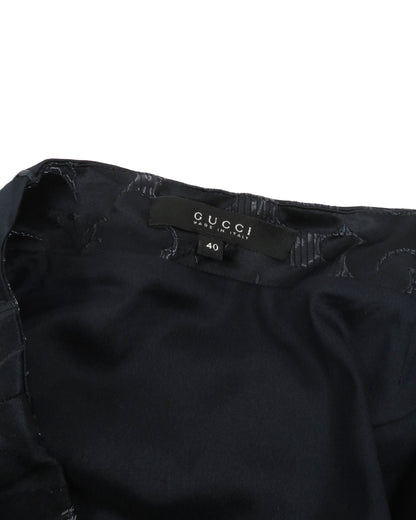 Black Gucci garment with tag on a white background
