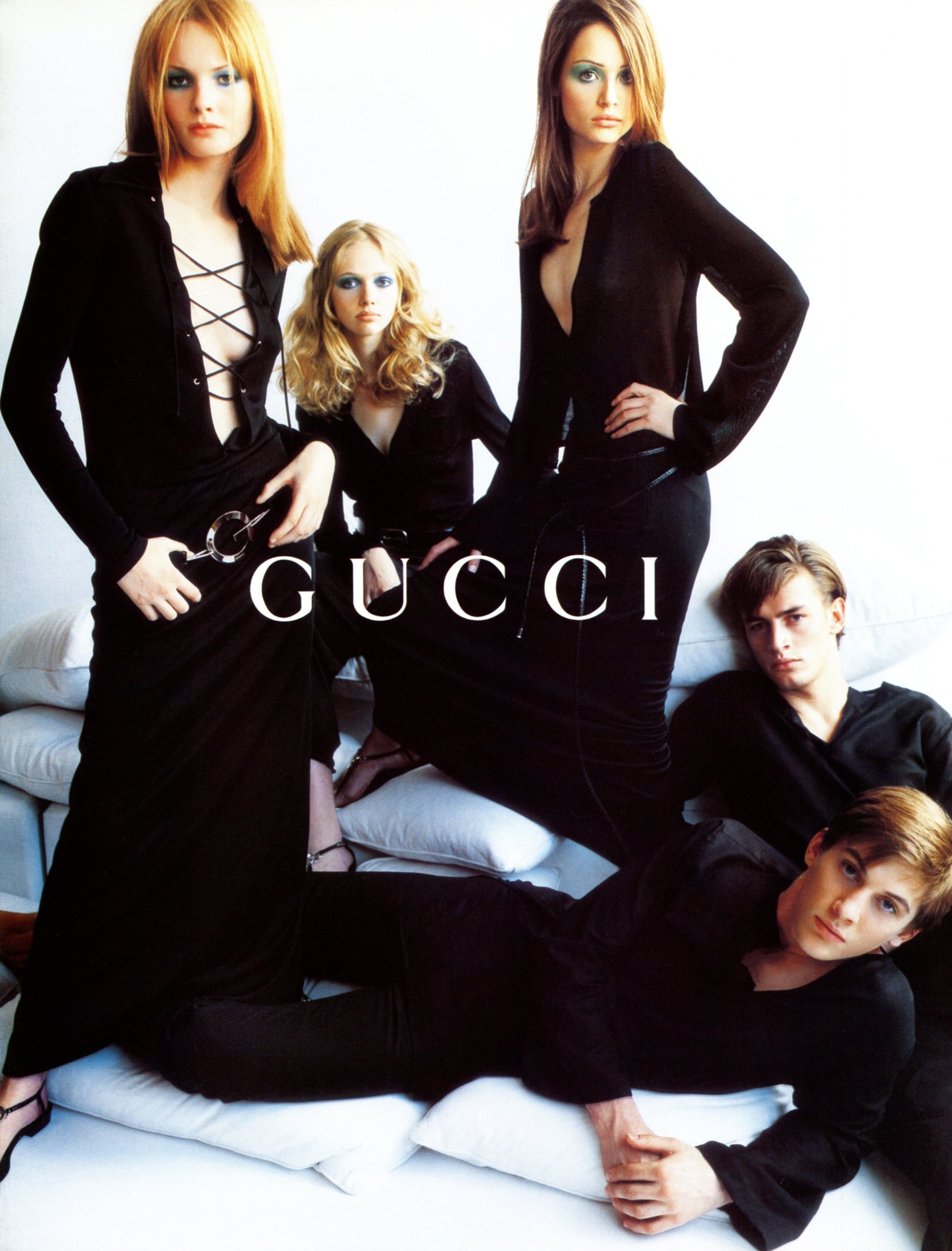 Gucci advertisement featuring models in black outfits on a white background