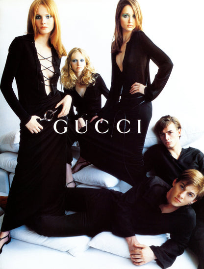 Gucci advertisement featuring models in black outfits on a white background