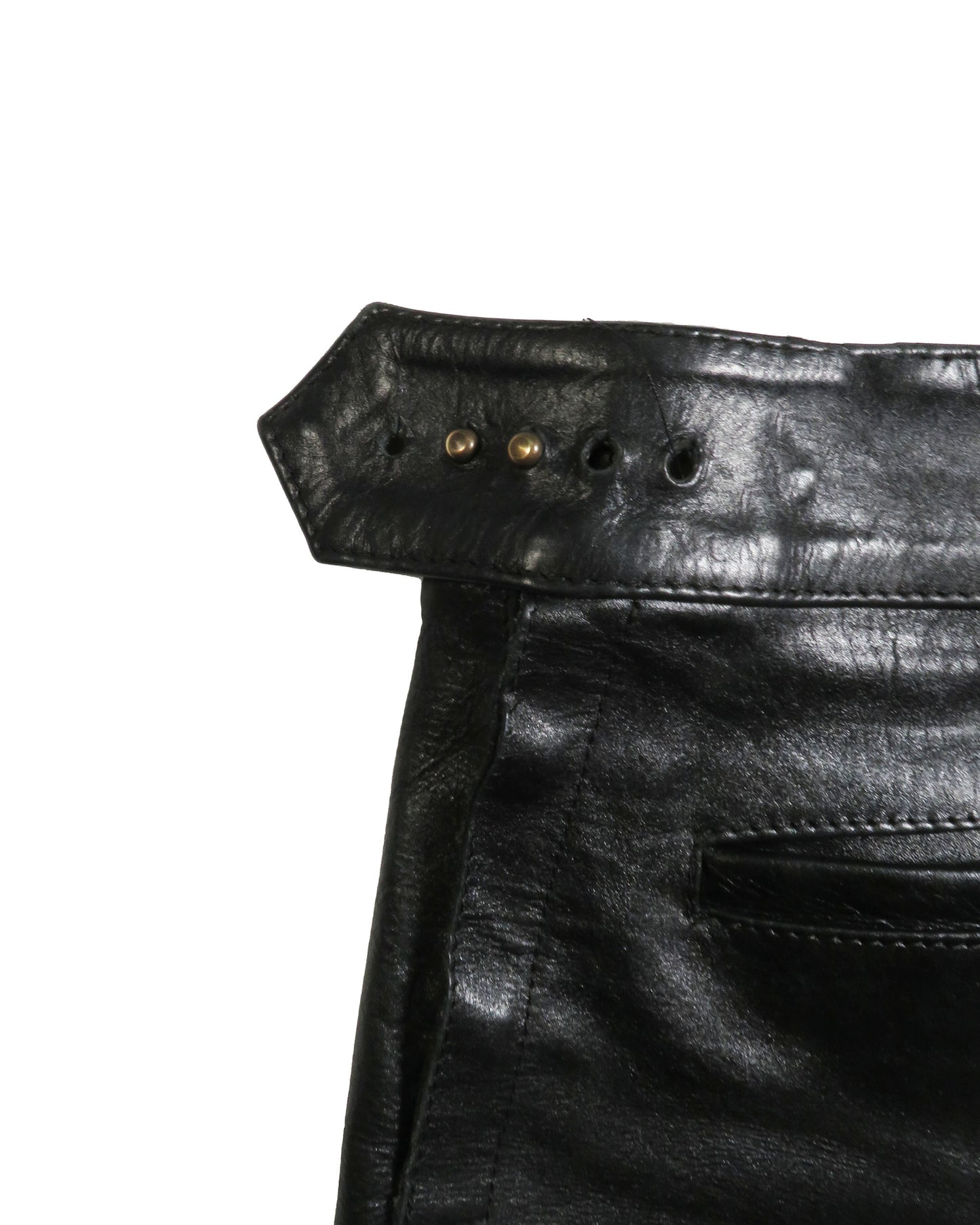 Close-up of black leather pants with stitching details on a white background