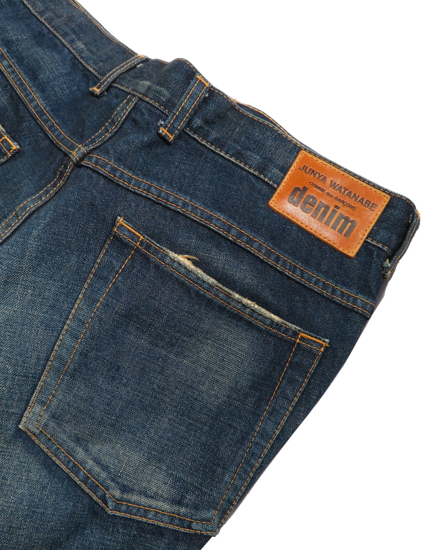 Close-up of blue denim jeans with a brand label on a white background